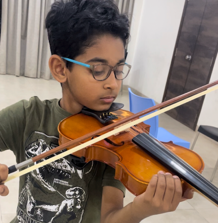 Student learning violin at Three Stars International Music Academy